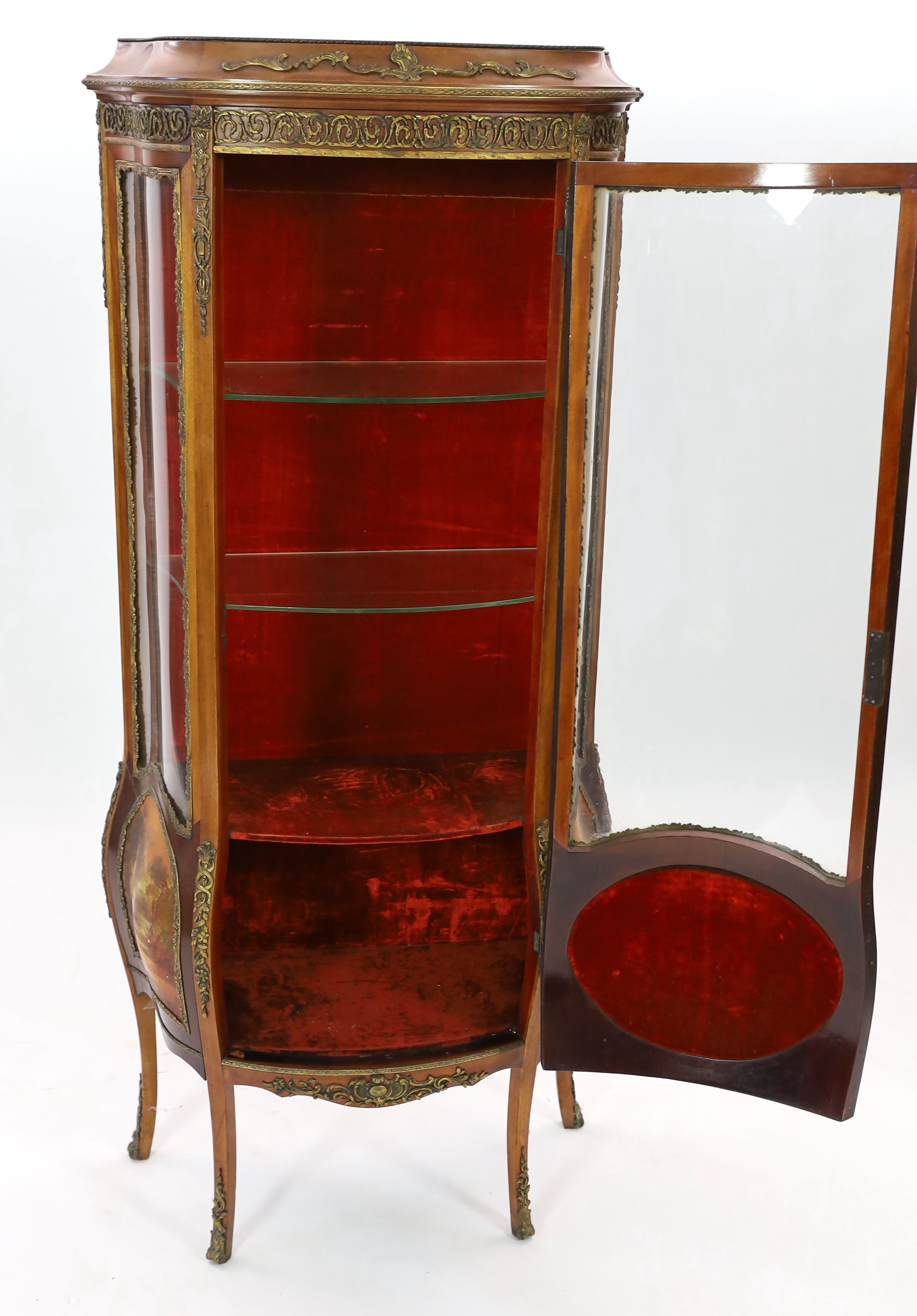 A French Vernis Martin style walnut vitrine, of bombé form with ormolu mounts, three quarter glazed door, lower panels, painted with scenes after Boucher and signed 'Albertine', on cabriole legs, 78cm wide, 42cm deep, 17
